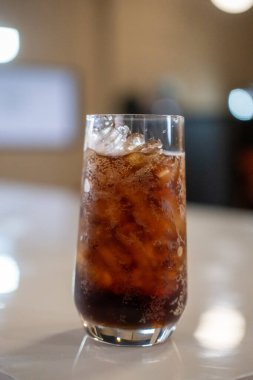 Masada bir bardak kola ve bokeh arkaplan.