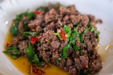 Karışık kızarmış Basil ve kıymalı biftek tabakta servis ediliyor. Pad Kra Pao olarak bilinen popüler bir Tayland yemeği.