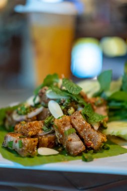 Baharatlı çıtır domuz salatası ya da Larb. Tayland yemeği, tabakta servis edilir..