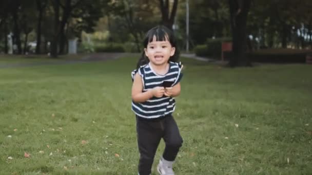 若いアジア系白人の混合人種の女の子は笑顔で公園を走るのを楽しんでいます 幸せな子供の子供時代 健康な子供の概念 — ストック動画
