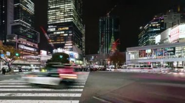 Tokyo, Japonya - 28 Kasım 2022: Araba trafiğinin zaman aşımı, kalabalık Shibuya geçidinde gece yürüyor. Turizm, Japonya turizmi, Asya taşımacılığı, Asya şehir hayatı kavramı