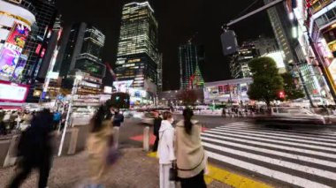 Tokyo, Japonya - 28 Kasım 2022: Araba trafiğinin zaman aşımı, kalabalık Shibuya geçidinde gece yürüyor. Turizm, Japonya turizmi, Asya taşımacılığı, Asya şehir hayatı kavramı