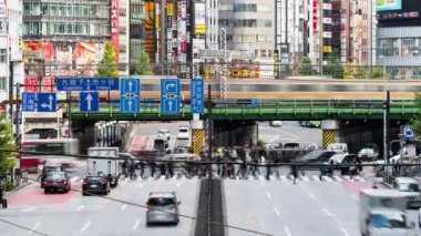 Tokyo, Japan - Dec 2, 2022: Time lapse of car traffic transportation on road, subway train, Japanese people walk cross junction in Shinjuku district, Tokyo Japan. Asia transport, Asian city life.