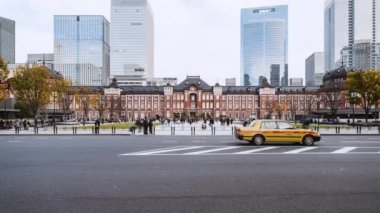 Tokyo, Japonya - 3 Aralık 2022: Yoldaki araba trafiğinin zamanlaması, Japonlar ve gezginler Tokyo İstasyonu binasında yürüyor. Tren ulaşımı, Asya seyahati turizm merkezi, Asya şehir yaşamı.
