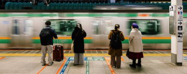 Tokyo İstasyonu ulaşım platformuna ulaşan tren hareket bulanıklığı, Japonlar binmek için sırada bekliyorlar. Banliyö yaşam tarzı, Japonya taşımacılığı, Asya seyahati turizmi veya Asya şehir yaşamı konsepti