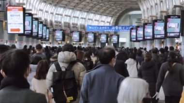 Tokyo, Japonya - 9 Aralık 2022: Büyük bir Asyalı kalabalık Shinagawa metro istasyonu koridorunda yürüyor. Japon şehir hayatı, Asya toplu taşımacılığı, Japon banliyö yaşam tarzı. Yavaş çekim