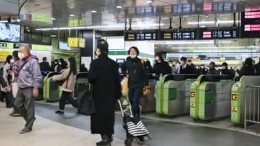 Tokyo, Japonya - 2 Aralık 2022: Japonlar, kalabalık Asyalı gezginler metro istasyonunun girişindeki otomatik bilet turnikesinden geçtiler. Asya toplu taşımacılığı, şehir hayatı, tren ulaşımı...