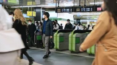 Tokyo, Japonya - 2 Aralık 2022: Japonlar, kalabalık Asyalı gezginler metro istasyonunun girişindeki otomatik bilet turnikesinden geçtiler. Asya toplu taşımacılığı, şehir hayatı, tren ulaşımı...
