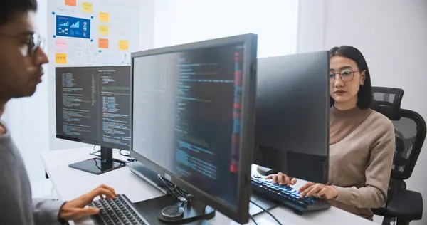 Junge Erwachsene Asiatische Männliche Weibliche Softwareentwickler Programmierprogramm Auf Dem Desktop lizenzfreie Stockfotos