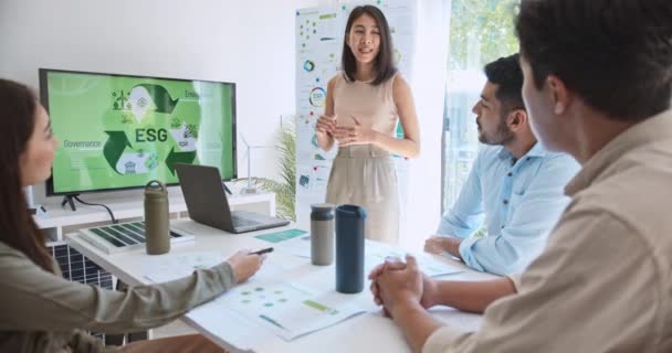 アジアの女性は モニター上のEsgトピックプレゼンテーション用のラップトップコンピュータを使用して チームミーティングで多民族ビジネスマンの若いグループをリードしています 持続可能なビジネスプラクティス 人々は家庭のコンセプトで働く — ストック動画