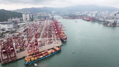 Deniz gemisi nakliye konteynırları kenetlenme, Hong Kong limanında yük yükleme, endüstriyel bölgede araba trafiği, insansız hava aracı görüntüsü. Taşımacılık sektörü