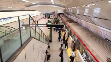 Osaka, Japonya - 26 Eylül 2023: Meşgul Japon yolcularının metro istasyonundaki ulaşım platformunda geçirdikleri zaman. Banliyö yaşam tarzı, tren taşımacılığı, Asya turizmi, Asya şehir hayatı.