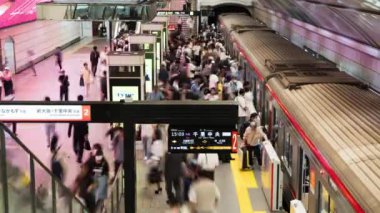 Osaka, Japonya - 26 Eylül 2023: Meşgul Japon yolcularının metro istasyonundaki ulaşım platformunda geçirdikleri zaman. Banliyö yaşam tarzı, tren taşımacılığı, Asya turizmi, Asya şehir hayatı.