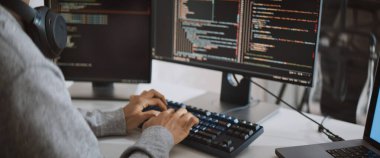 Genç yetişkin Asyalı erkek yazılım geliştirici kodlama programı masaüstü bilgisayarında. Evden çalışan, uzaktan çalışan, serbest programcılık yapan zeki dijital göçebe yaşam tarzı konsepti. Kapat.