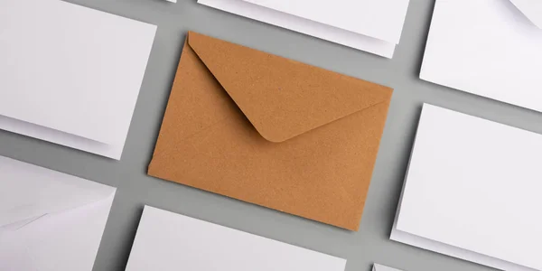 白い封筒とポストカードとテーブルの上の1つのクラフト封筒 — ストック写真