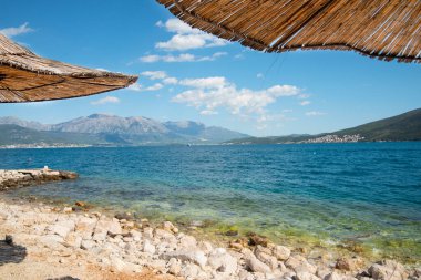 Doğal malzemeden yapılmış plaj şemsiyeleri - güneşe karşı saman - dinlenmek için bir cennet