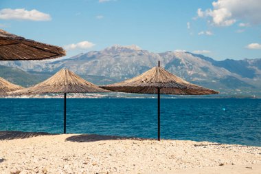 Doğal malzemeden yapılmış plaj şemsiyeleri - güneşe karşı saman - dinlenmek için bir cennet