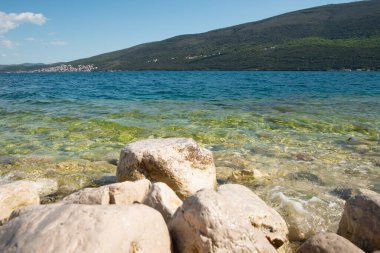 Deniz kıyısında büyük taşlar. Adriyatik ve dağların manzarası. Karadağ.