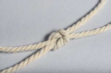 Dar bir düğümü gösteren, gücünü ve pratiğini vurgulayan bir ipin yakın plan görüntüsü..