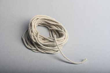 Gri yüzeye sarılı doğal pamuk bir makara, çeşitli zanaat faaliyetleri için mükemmel..