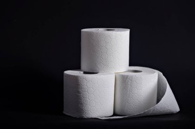 Yumuşak beyaz tuvalet kağıdı ruloları istiflenmiş, her türlü banyo veya tuvalet ayarında kullanıma hazır..