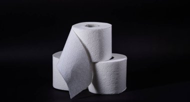 Üç rulo yumuşak, beyaz tuvalet kağıdı, herhangi bir banyo için düzgünce istiflenmiş..