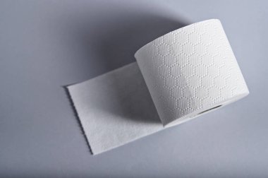 Temiz bir yüzeye sergilenen yumuşak, beyaz tuvalet kâğıdı rulosu, tuvalet hijyeninin gerekliliklerini vurguluyor..