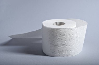 Tek rulo yumuşak beyaz tuvalet kağıdı düz bir zeminde düzgünce oturur ve banyo hijyenine önem verir..