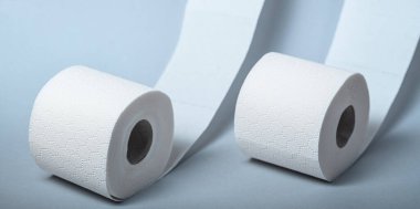 İki rulo yumuşak beyaz tuvalet kağıdı temiz bir banyoda hijyenik uygulamalar için hazır..