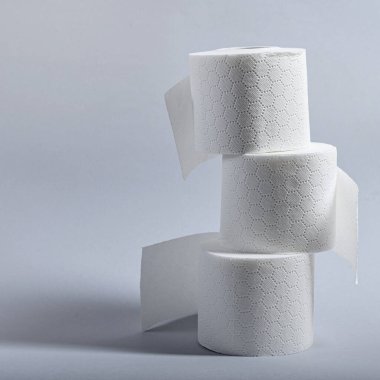 Üç rulo yumuşak, beyaz tuvalet kağıdı zarif bir şekilde istiflenir ve banyoda hijyen sağlanır..