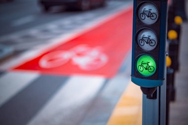 Görünür bisiklet trafik ışığı yeşil ışık gösteriyor. Bu da bisikletçiler için şehir caddesinde belirlenmiş bisiklet yolu boyunca güvenli geçiş anlamına geliyor..