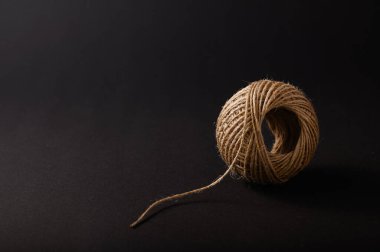 Bir doğal sicim topu karanlık bir arka planda tek başına oturur ve minimalist bir düzende dokusunu ve organik hislerini vurgular..