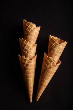 Beş waffle külahı, yaz şenliklerinde çeşitli dondurma tatları servis etmek için ideal bir arka fona mükemmel bir şekilde istiflenmiş..