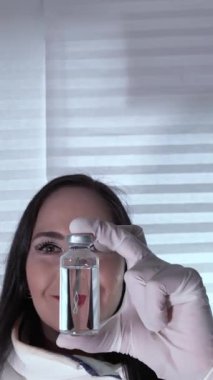 Biyolojik moleküler araştırmadaki kadın bilim adamı elinde insan DNA 'sından kopyalanmış bir şişe biyomoleküler ilaç tutuyor.