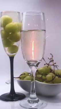 Noel arifesinde ya da Yeni Yıl arifesinde yanan havai fişekler, içinde köpüklü beyaz şarap bulunan bir çift bardağı döndürerek yakıyor.