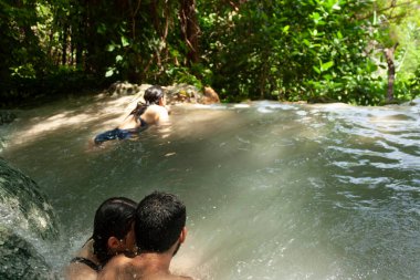 Çift ve arkadaşı Hidalgo eyaletinde yağmur ormanlarının ortasında bir çukurda su banyosu yapıyor. Meksika macerası ve eko-turizm gezisi.