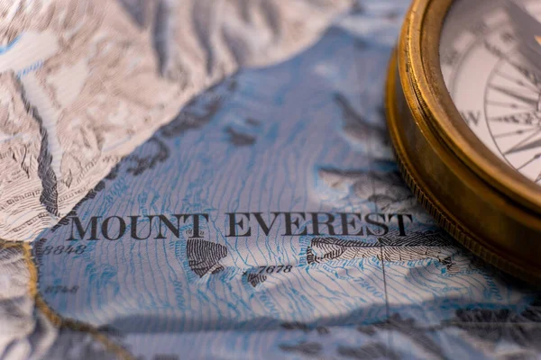 Close up of vintage compass on map detail of Mt. Everest topographical map showing contour lines, elevation. High quality photo