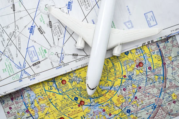 Close up of a miniature airplane on FAA aviation sectional navigation maps showing restricted fly zones around airports. High quality photo