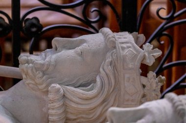 Taştan yontulmuş kraliyet heykelleri ilkel bir taç ve ortaçağ kralının sakallı yüzünü gösteren yakın plan fotoğraflarda yer alıyor. Yüksek kalite fotoğraf