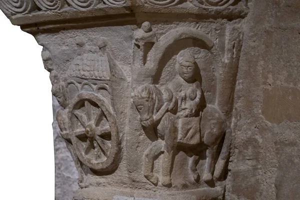 Bir katedraldeki ortaçağ sütunundan oyulmuş taş sütunlar at sırtında birini gösteriyor, tekerlekli bir araba. İlkel biçim