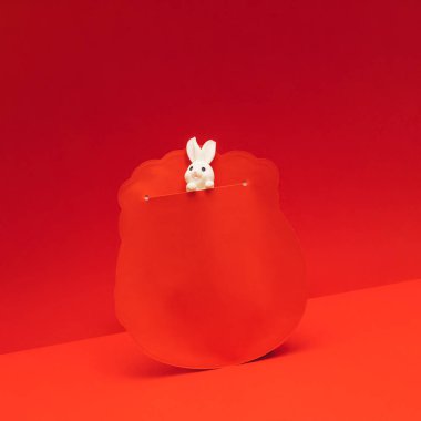 Geleneksel Çin kırmızı zarfında şirin küçük beyaz bir tavşan. 2023. Ay Yeni Yılı, Tavşan Yılı.