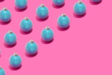 Renkli, pürüzsüz desenli, pastel pembe arka planda mavi, karlı Noel mücevherleri. Yeni Yıl ve Kış Tatil kompozisyonu Minimalist tarzında.
