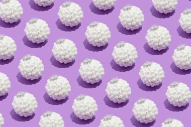 Renkli, pürüzsüz desenli, beyaz, karlı Noel süslemeleri, pastel mor arka planda. Yeni Yıl ve Kış Tatil kompozisyonu Minimalist tarzında.