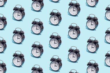Seamless pattern of black retro alarm clocks  show 3 o'clock and one shows 2. Changing clock from summer time to winter time. Shifting the clock hands back in autumn.