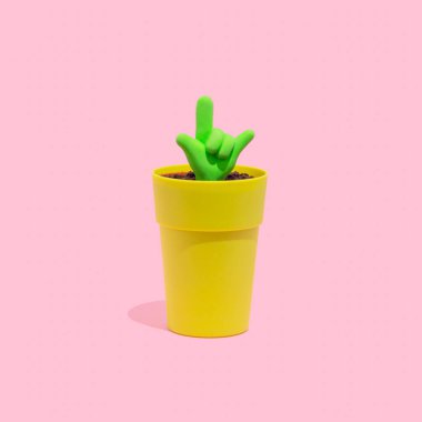 Floresan yeşili ILY, Pastel pembe arka planda küçük bir tencerede büyüyen sembol ikonunu seviyorum. El hareketleri, aşk kavramı..