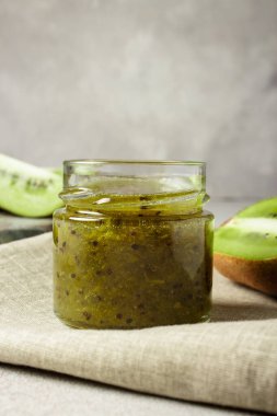 Kavanozda ev yapımı kivi reçeli ve beton arka planda fotokopi alanı olan kivi sinekleri..