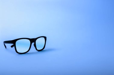 Black sunglasses with Multicolor Mirror Lens on blue background. Polarized sunglasses with UV protection. Copy space.