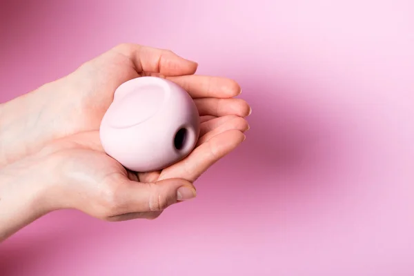 stock image womens hands carefully holding pink vacuum clitoral stimulator on a pink background. Place for text. Sex shop concept. Copy space.