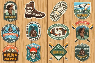 Yürüyüş serüveni amblemleri, logolar, rozetler. Yürüyüşle ilgili tipografik alıntı. İnsan iskeleti, yürüyüş direği, yürüyüş botu, kozalak, dağlar.