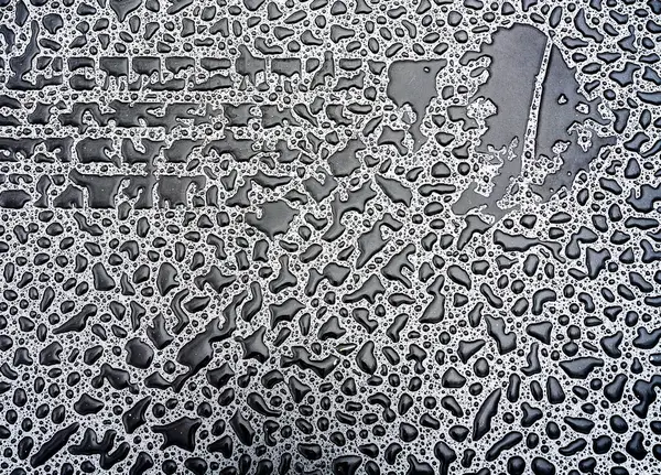 Bir araba lastiğinin açısı yağmurlu bir yolda iz bırakır.